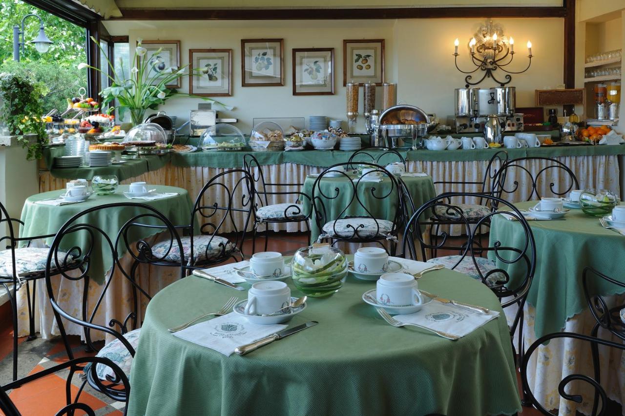 een eetkamer met twee tafels met groene tafelkleden bij Hotel Farnese in Rome