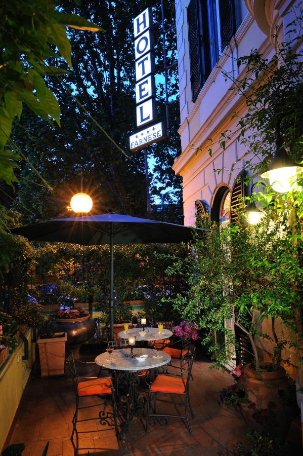 een tafel met een parasol voor een gebouw bij Hotel Farnese in Rome