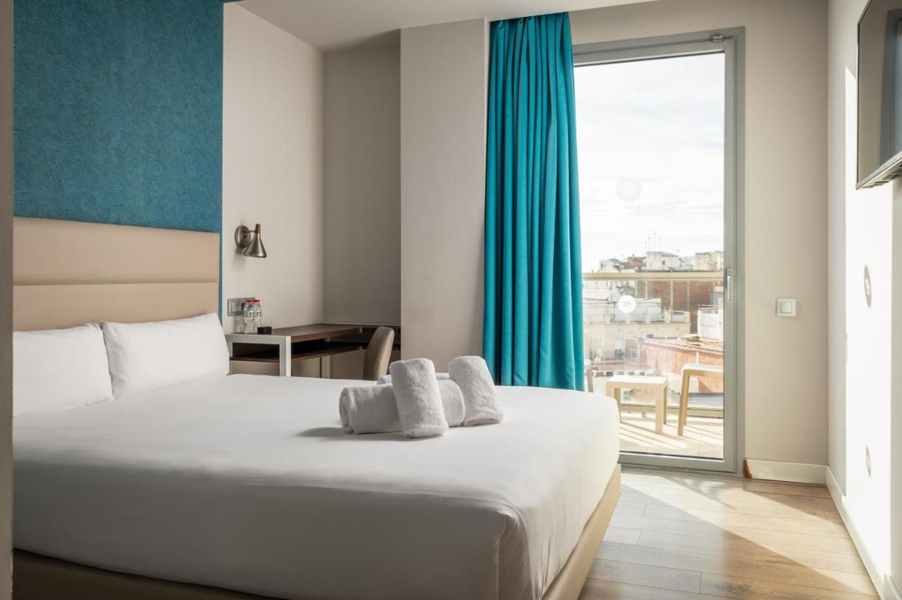een hotelkamer met een bed en een groot raam bij Arya Stadium Hotel in Barcelona