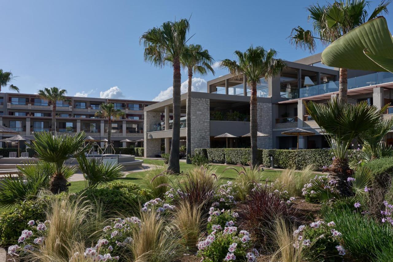 een exterieurfoto van een gebouw met palmbomen bij Atlantica Kalliston Resort - Adults Only in Stalós