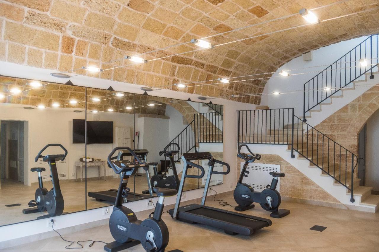 een sportschool met loopbanden en crosstrainers en een trap bij Masseria Le Mandorle in Ugento