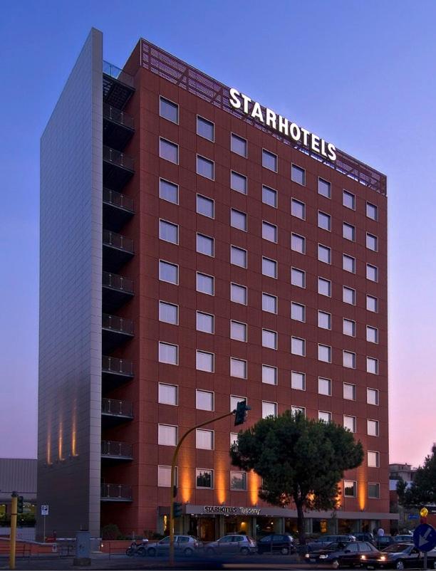 een hotel met een uithangbord aan de zijkant van een gebouw bij Starhotels Tuscany in Florence