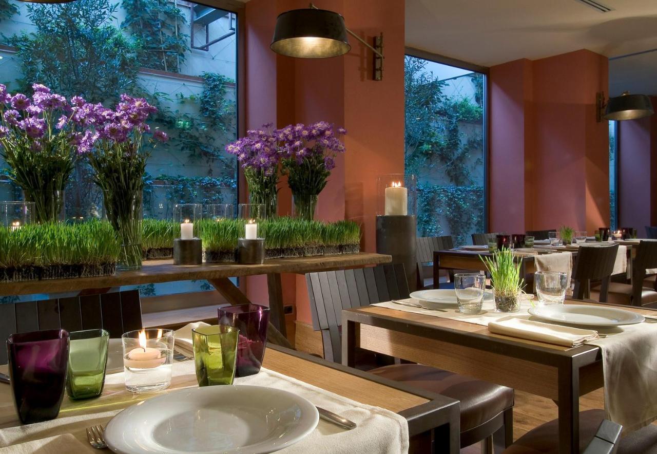 een restaurant met tafels en stoelen met paarse bloemen bij Starhotels Tuscany in Florence