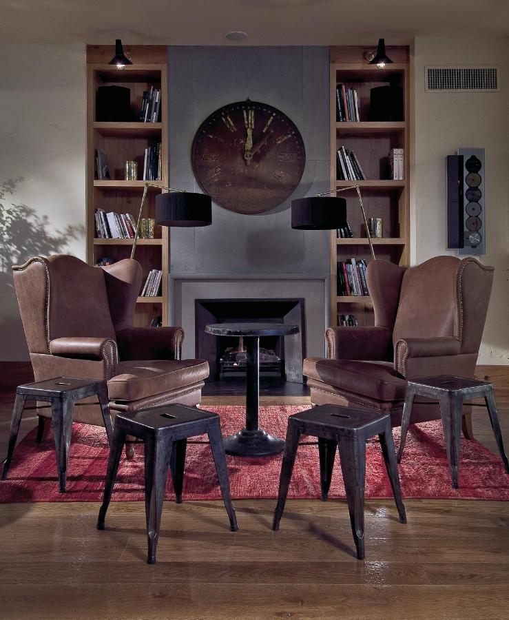 een woonkamer met twee stoelen en een open haard bij Starhotels Tuscany in Florence