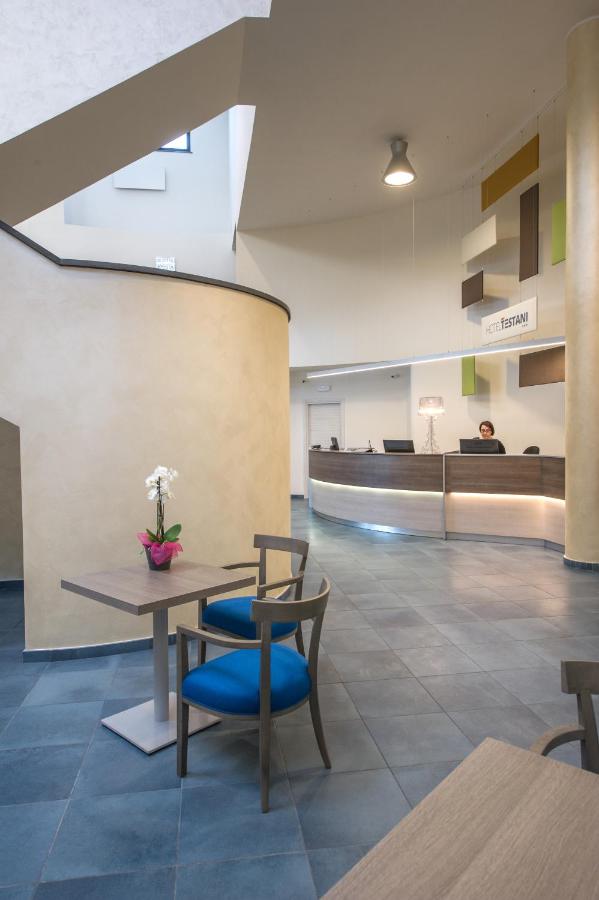 een lobby met een tafel en een blauwe stoel bij Hotel Testani Colleferro in Colleferro