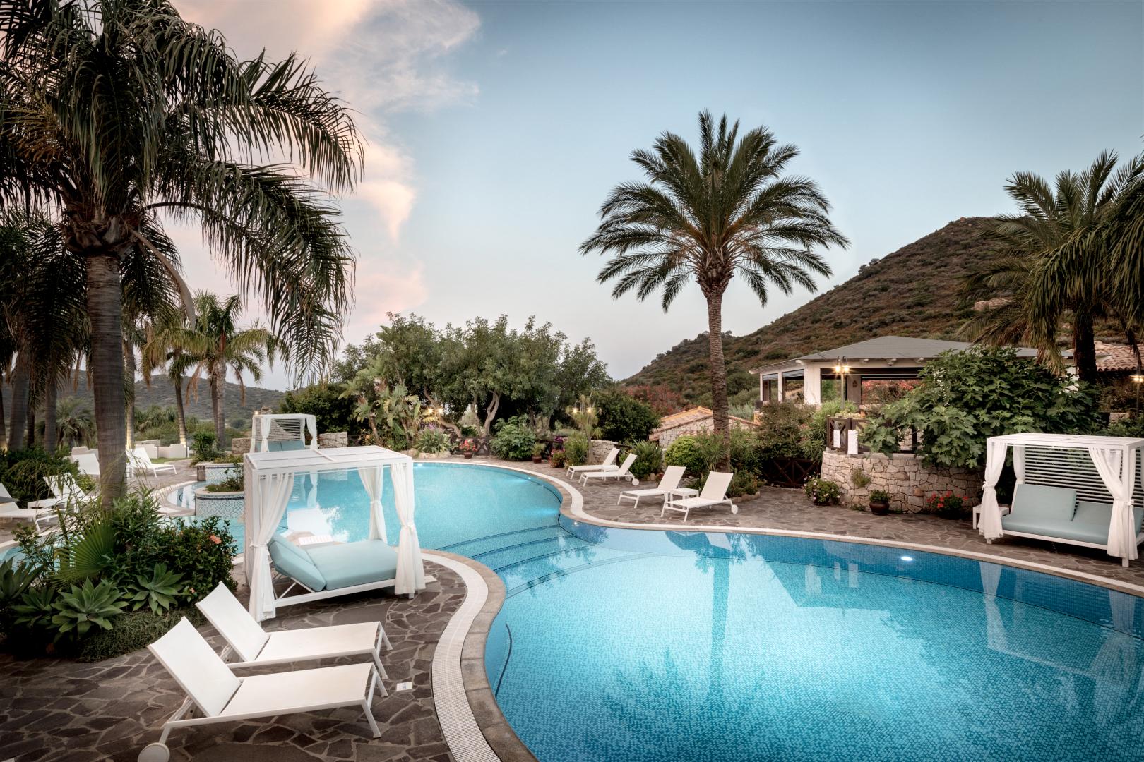Zwembad omringd door palmbomen — Cruccuris Resort