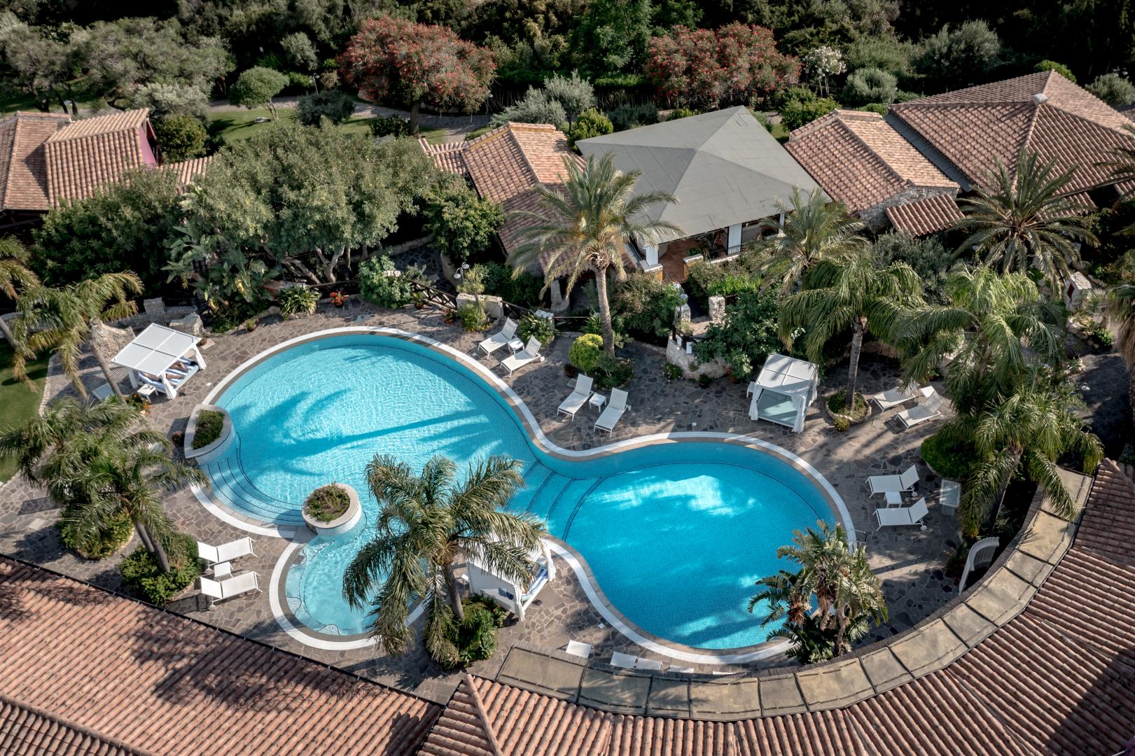 Zwembad omringd door palmbomen — Cruccuris Resort