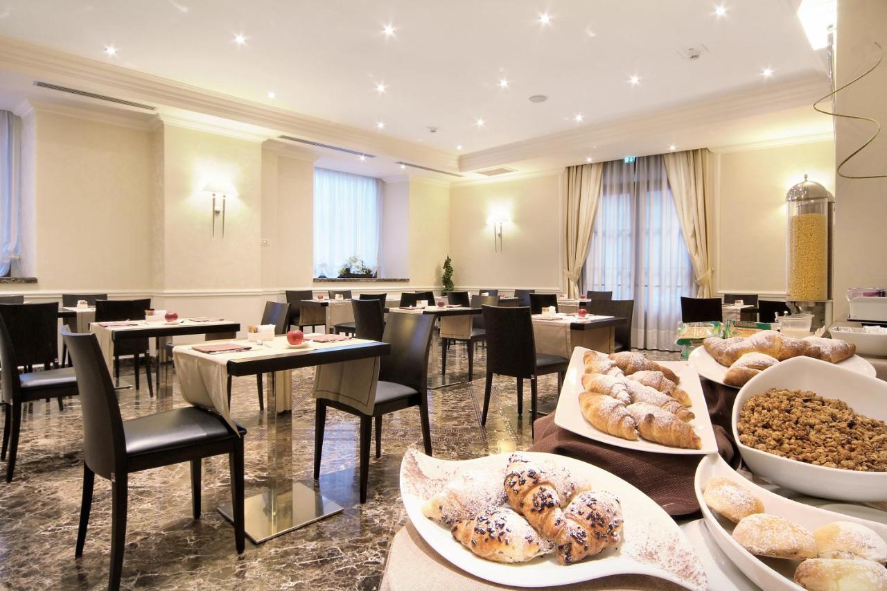een restaurant met tafels en stoelen en gerechten die tentoongesteld staan bij Il Principe Hotel Catania in Catania