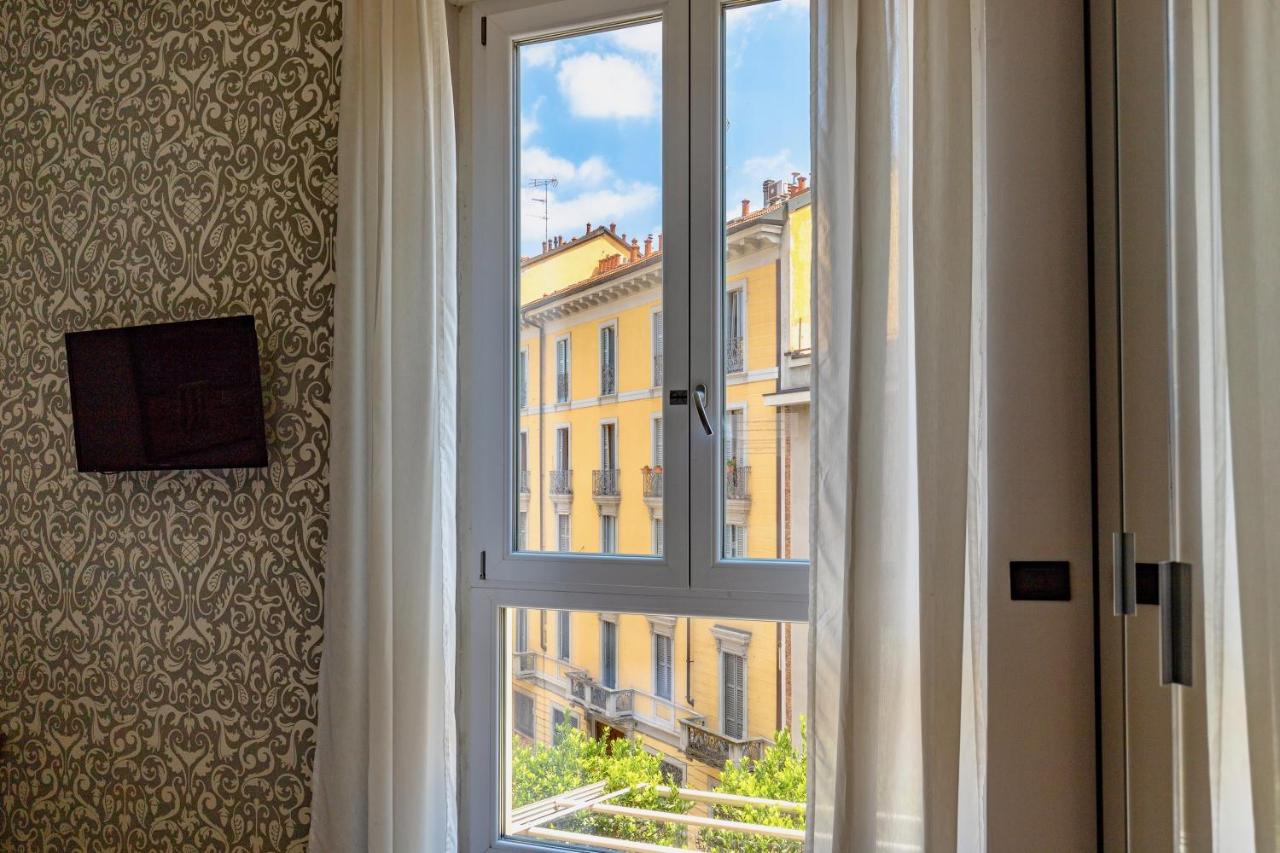 een raam met uitzicht op een gebouw bij Aiello Rooms in Milaan +20 foto's