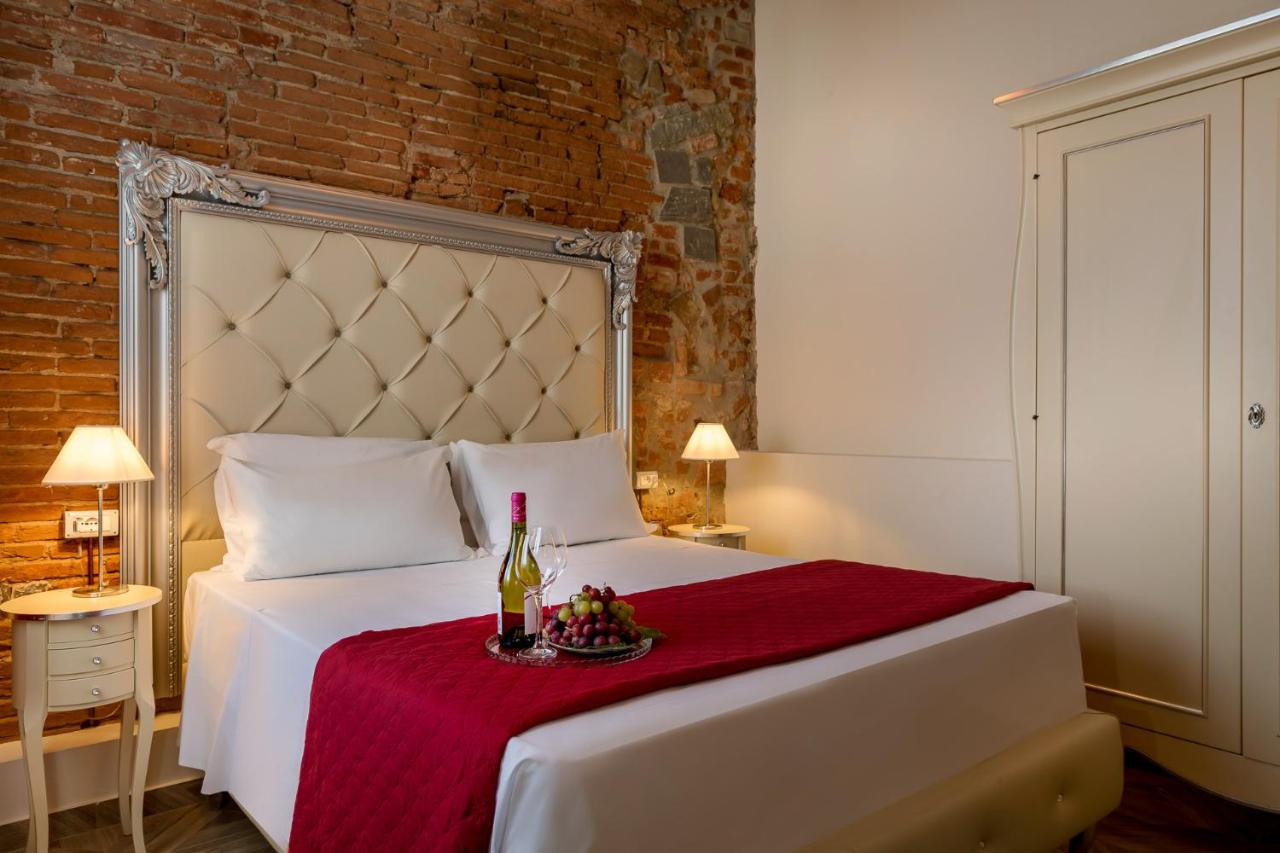 een slaapkamer met een wit bed en een fles wijn bij Residenza Conte di Cavour & Rooftop - dBe Hotels in Florence