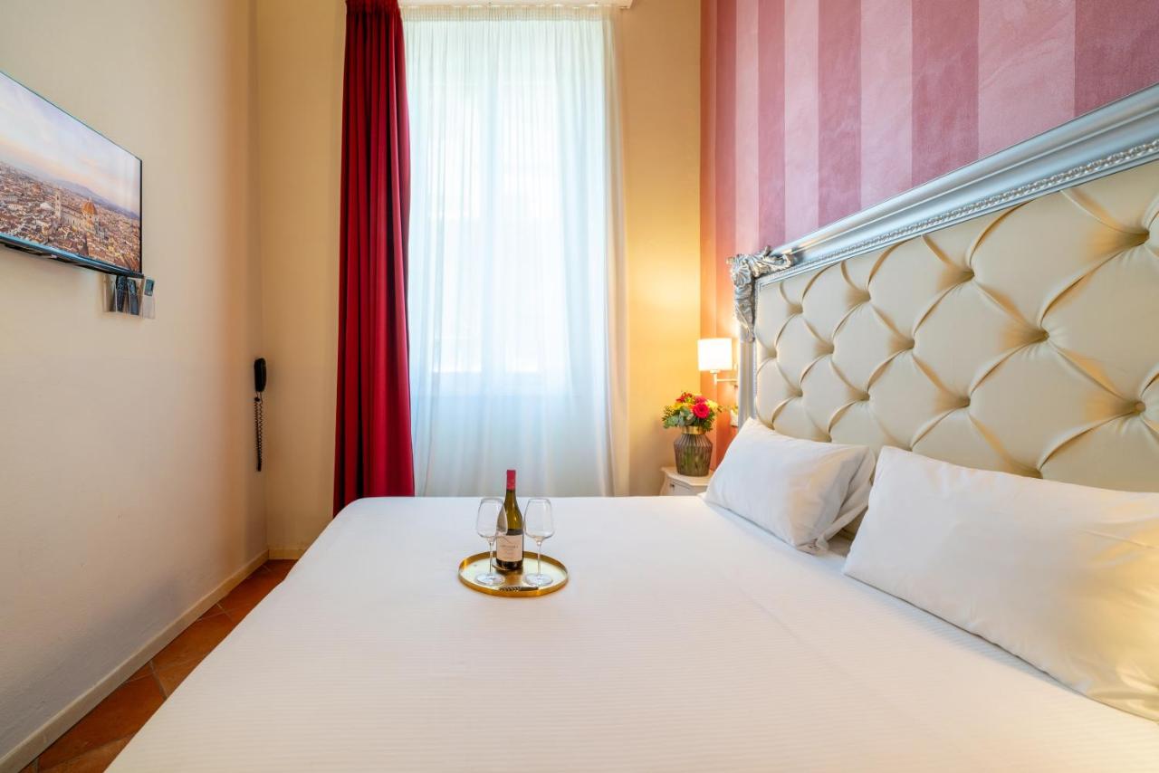 een slaapkamer met een bed waarop een fles wijn staat bij Residenza Conte di Cavour & Rooftop - dBe Hotels in Florence