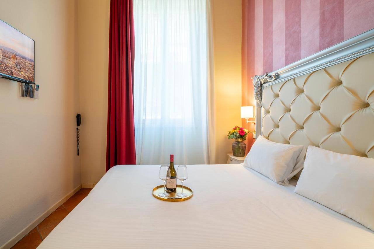 een bed met een fles wijn en een glas erop bij Residenza Conte di Cavour & Rooftop - dBe Hotels in Florence
