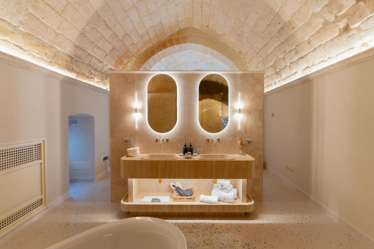 een badkamer met een wastafel en twee spiegels bij Palazzo Del Duca Hotel & Restaurant in Matera