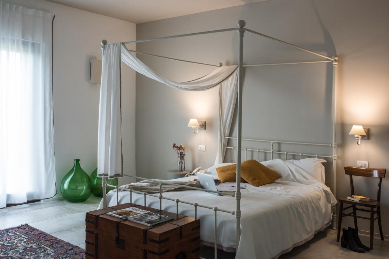 een slaapkamer met een bed met een metalen baldakijn bij Masseria Fontana di Vite in Matera +102 foto's