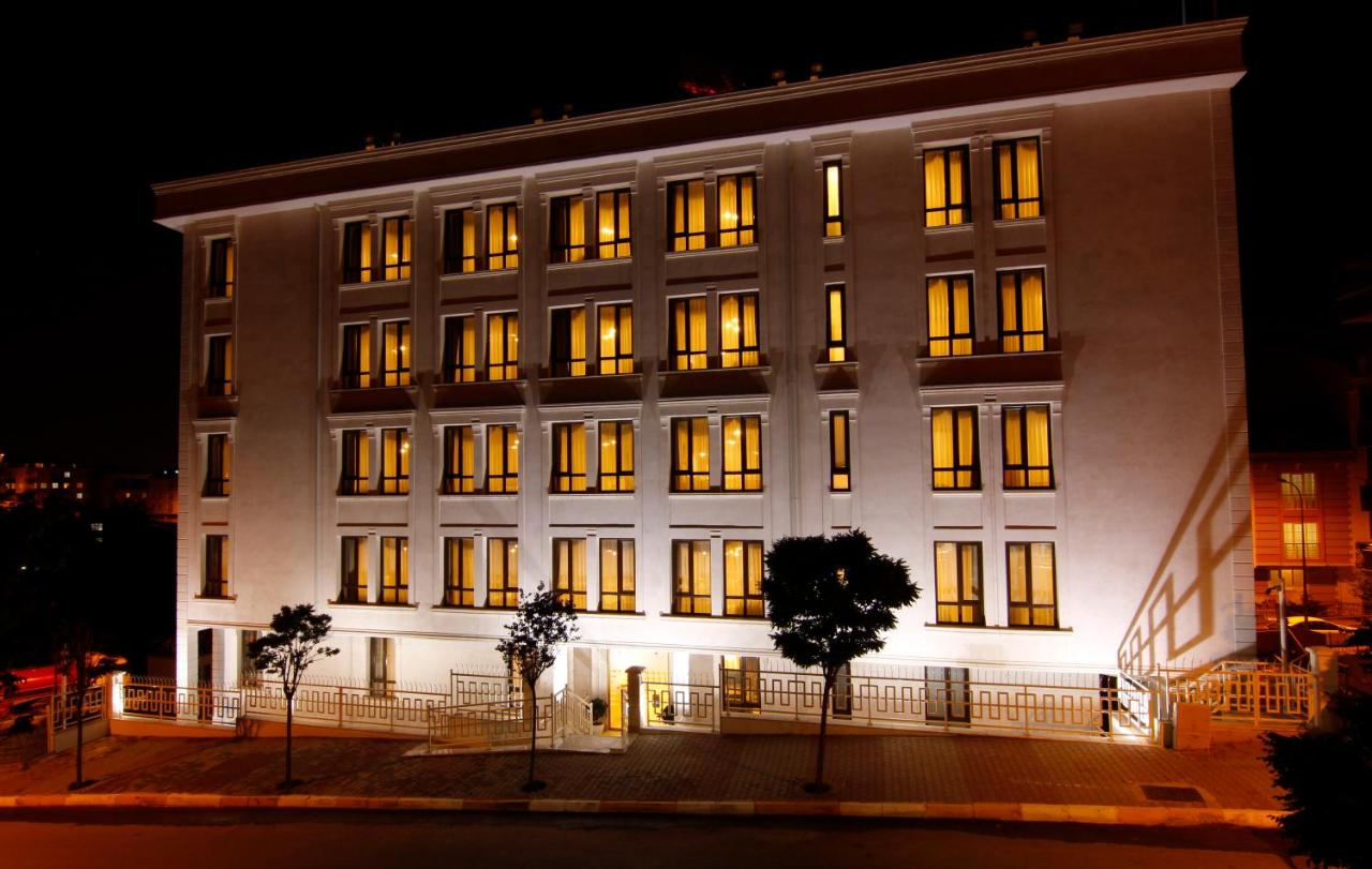 een groot wit gebouw met 's nachts verlichte ramen bij ZİN D Home Çekmeköy Suit Otel in Istanbul