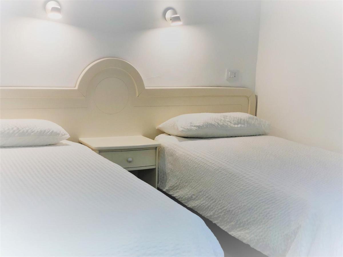 Twee bedden in een kleine kamer met witte muren. bij Acapulco Ocean View in San Agustin