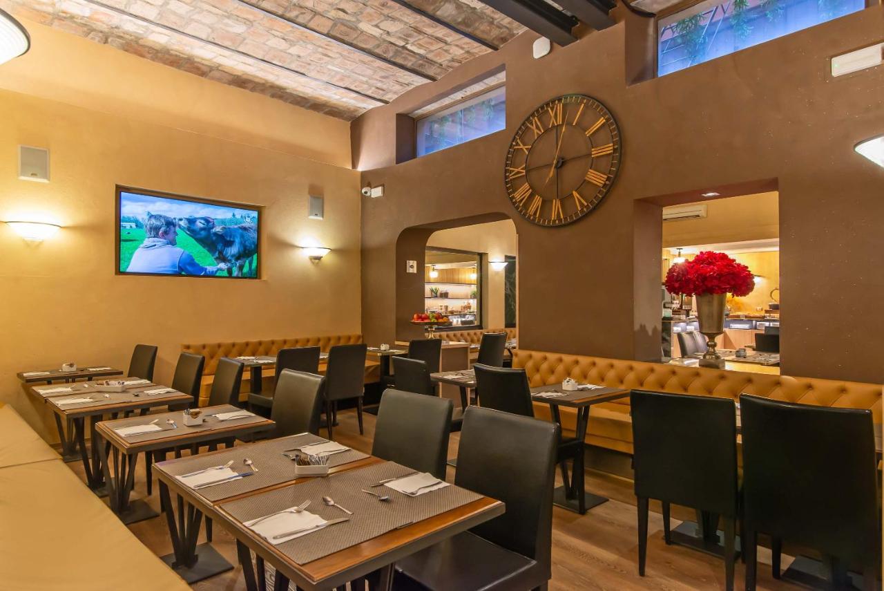 een restaurant met tafels en een grote klok aan de muur bij Hotel Accademia in Rome +223 foto's