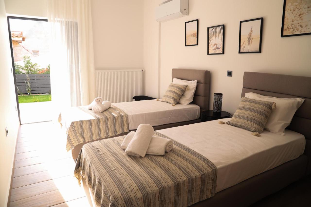 een slaapkamer met twee bedden en een raam bij Villa Achilleas by the sea in Anavissos
