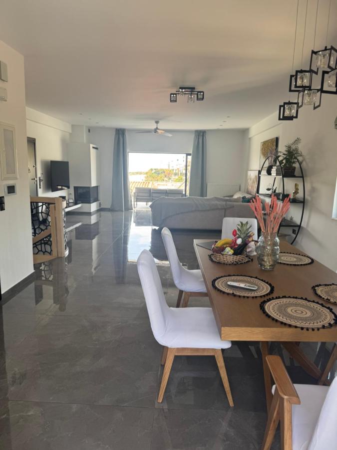 een woonkamer met een tafel en een bank bij Villa Achilleas by the sea in Anavissos