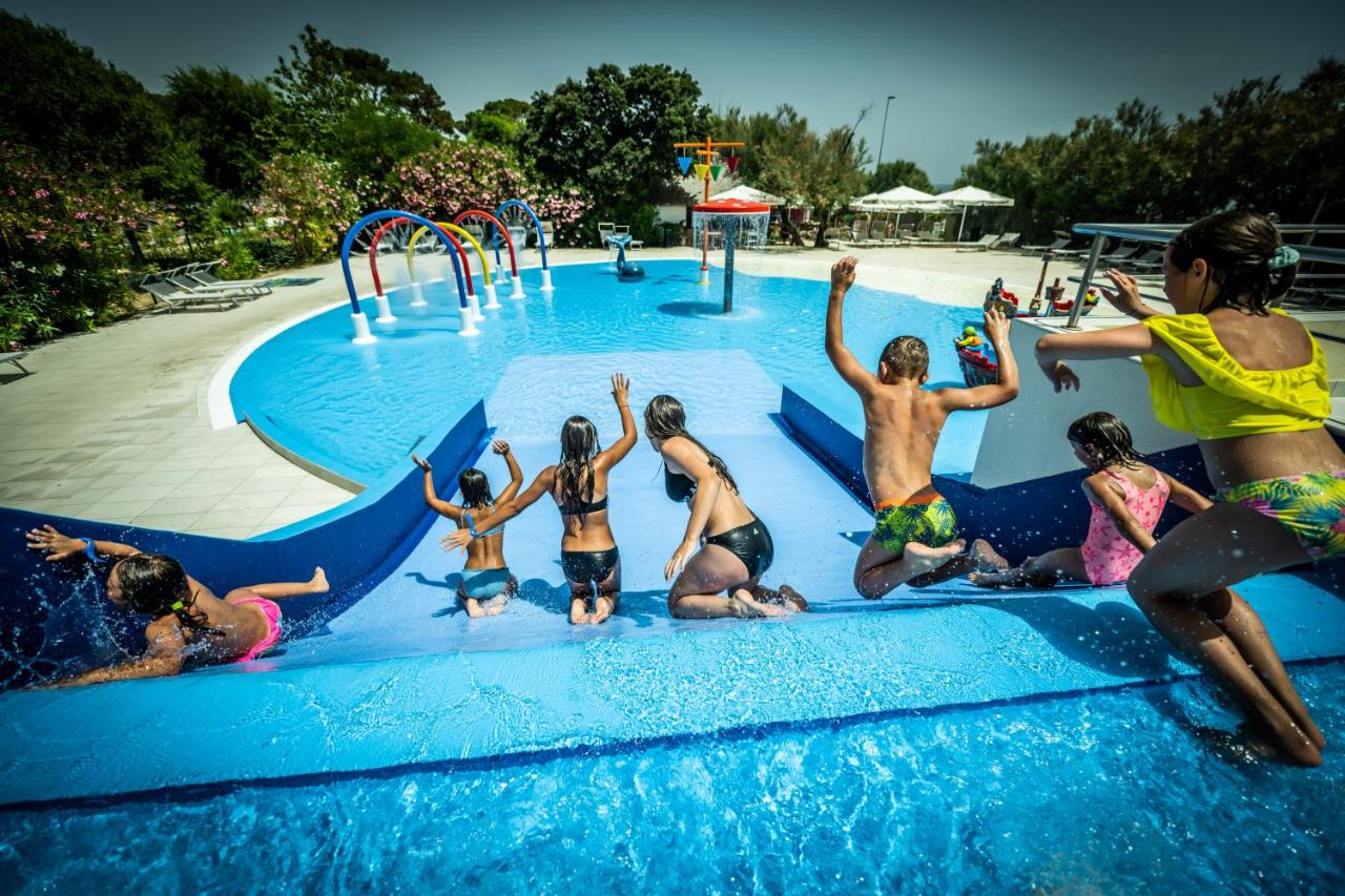 een groep kinderen die in een zwembad spelen bij Villaggio San Francesco - Adria Holiday Mobile Homes in Duna Verde