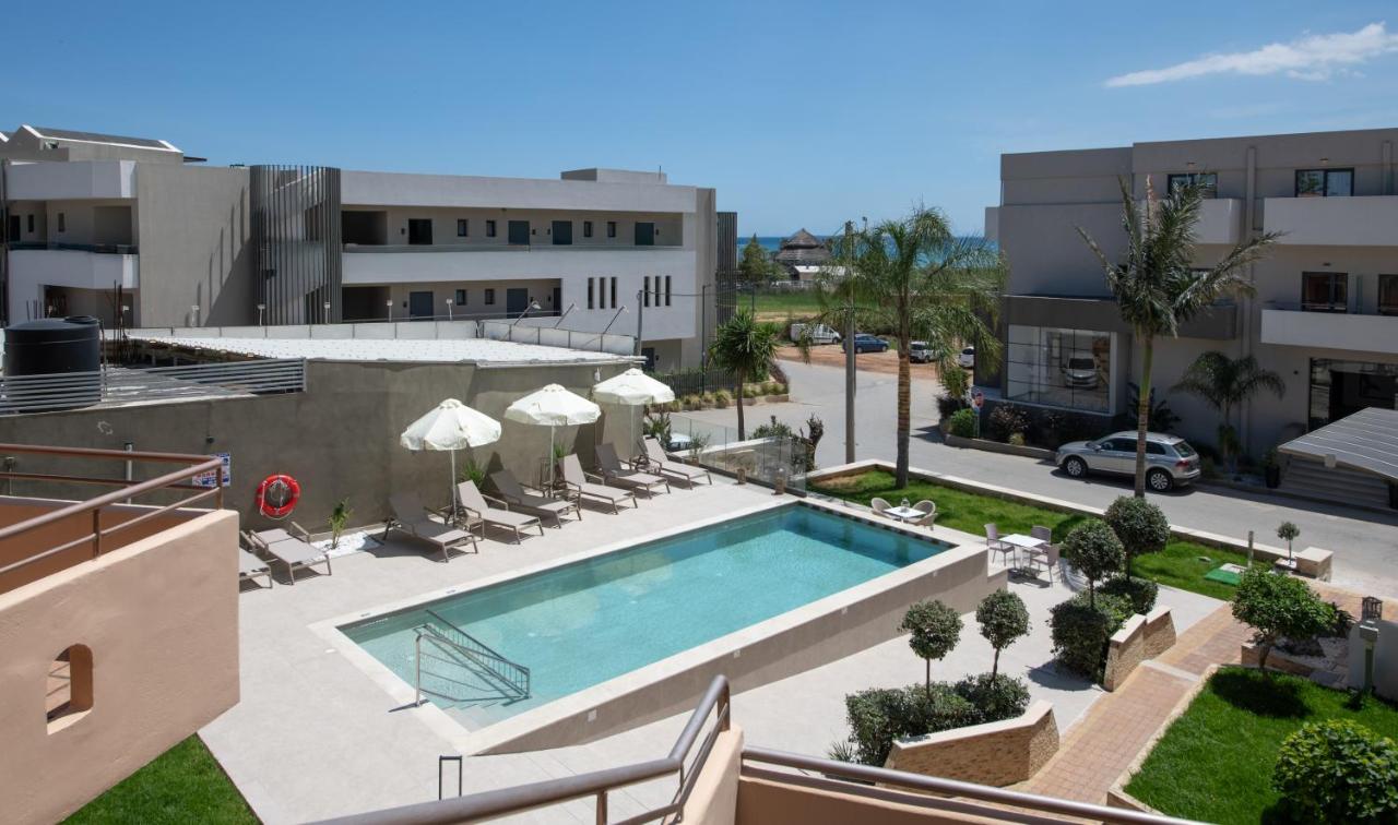 Een bovenaanzicht van een zwembad met stoelen en parasols. bij Eko Suites in Georgioupolis