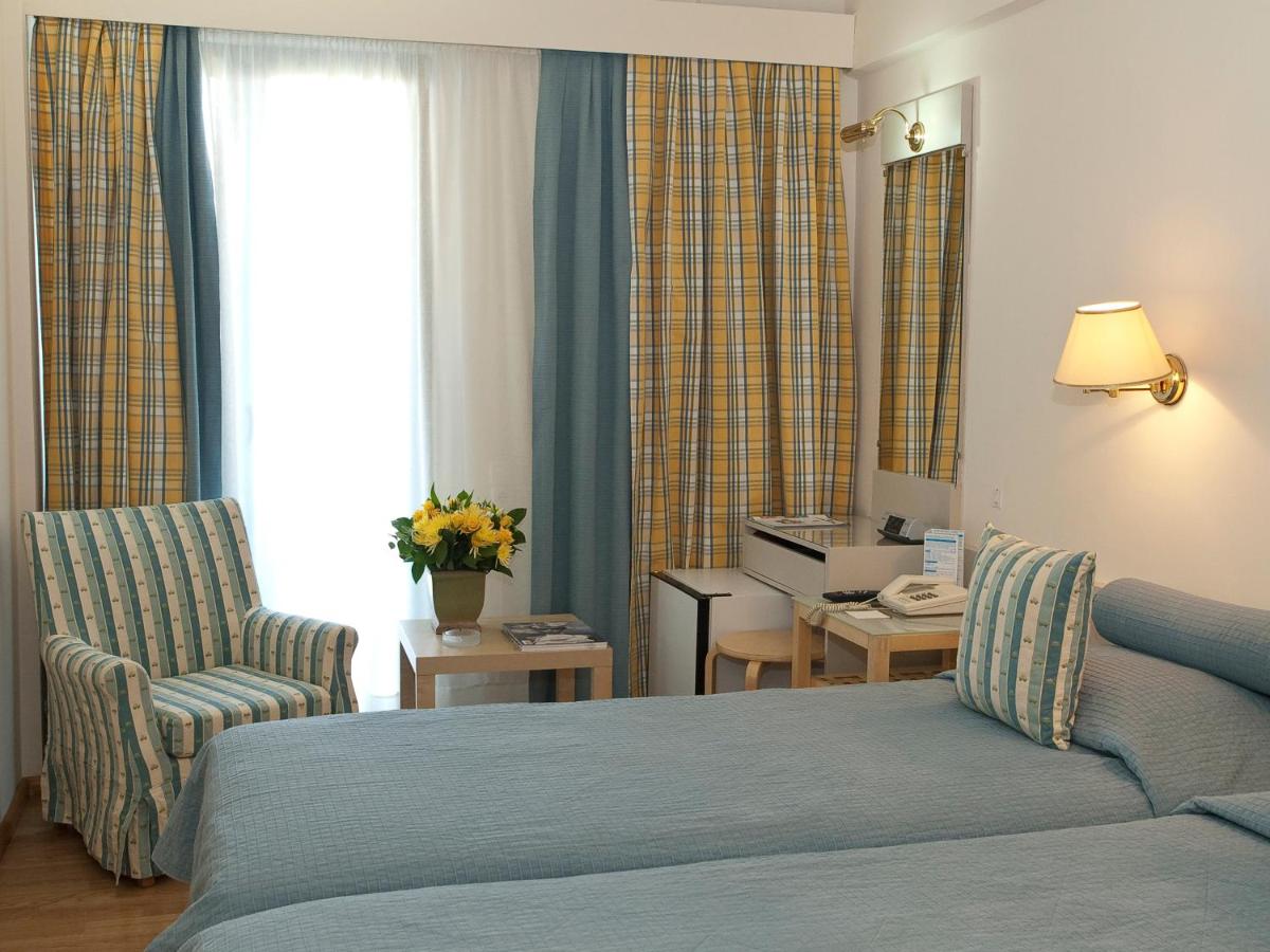een hotelkamer met een bed en een stoel bij The Park Hotel Piraeus in Piraeus