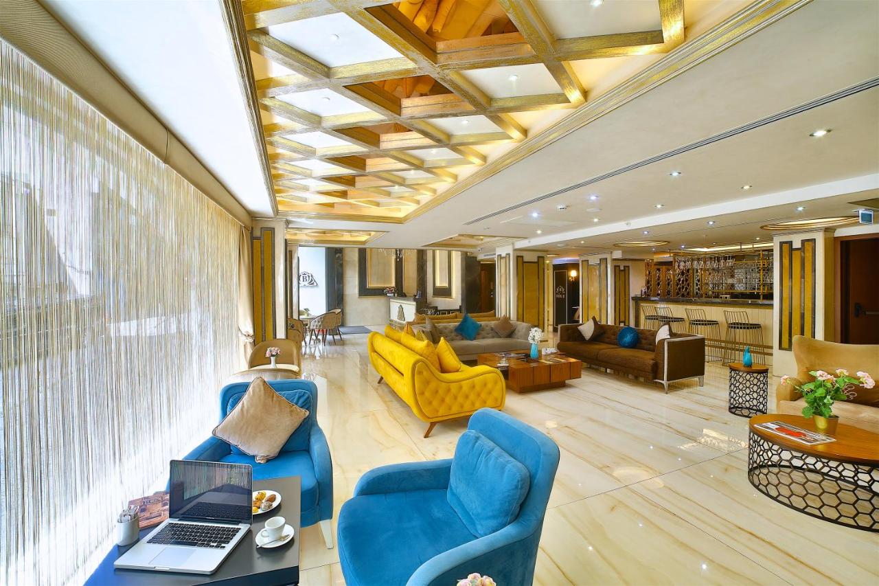 een woonkamer met blauwe stoelen en een laptop op een tafel bij Büke Hotel Şişli in Istanbul