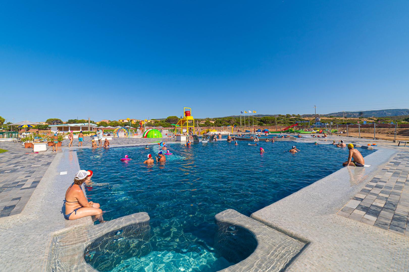 Buitenzwembad met ligbedden — Camping Village Baia Blu La Tortuga