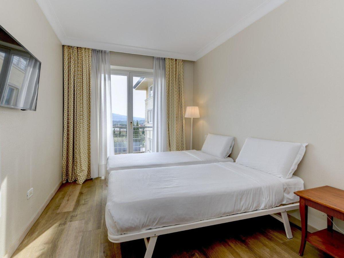 een witte slaapkamer met een bed en een raam bij B&B Hotel Affi - Lago di Garda in Affi