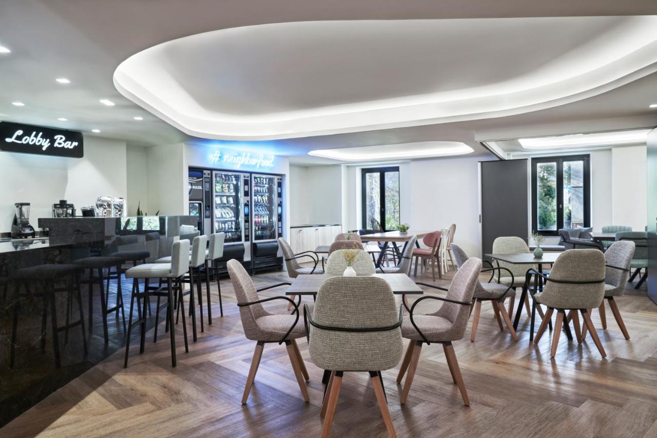 een restaurant met tafels en stoelen en een bar bij NLH MONASTIRAKI - Neighborhood Lifestyle Hotels in Athene