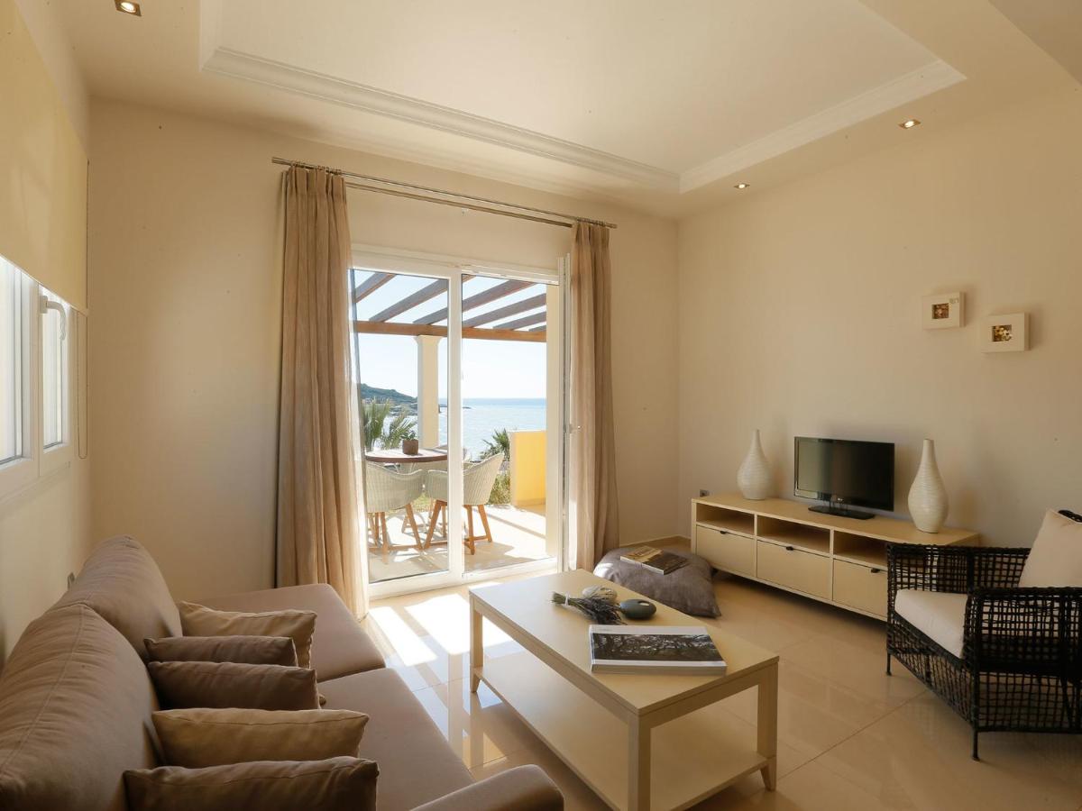 een woonkamer met een bank en een tv bij Pictures Suites in Agios Stefanos