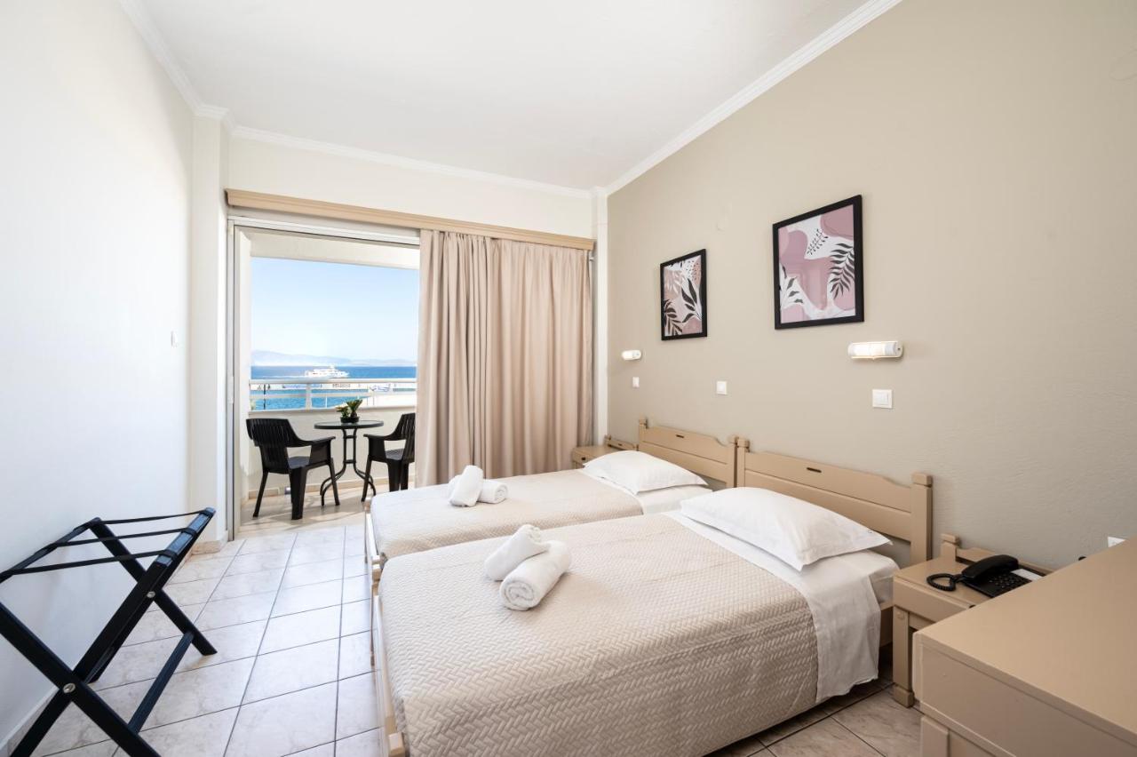 een hotelkamer met twee bedden en uitzicht op de oceaan bij Zephyros Hotel in Kos-stad
