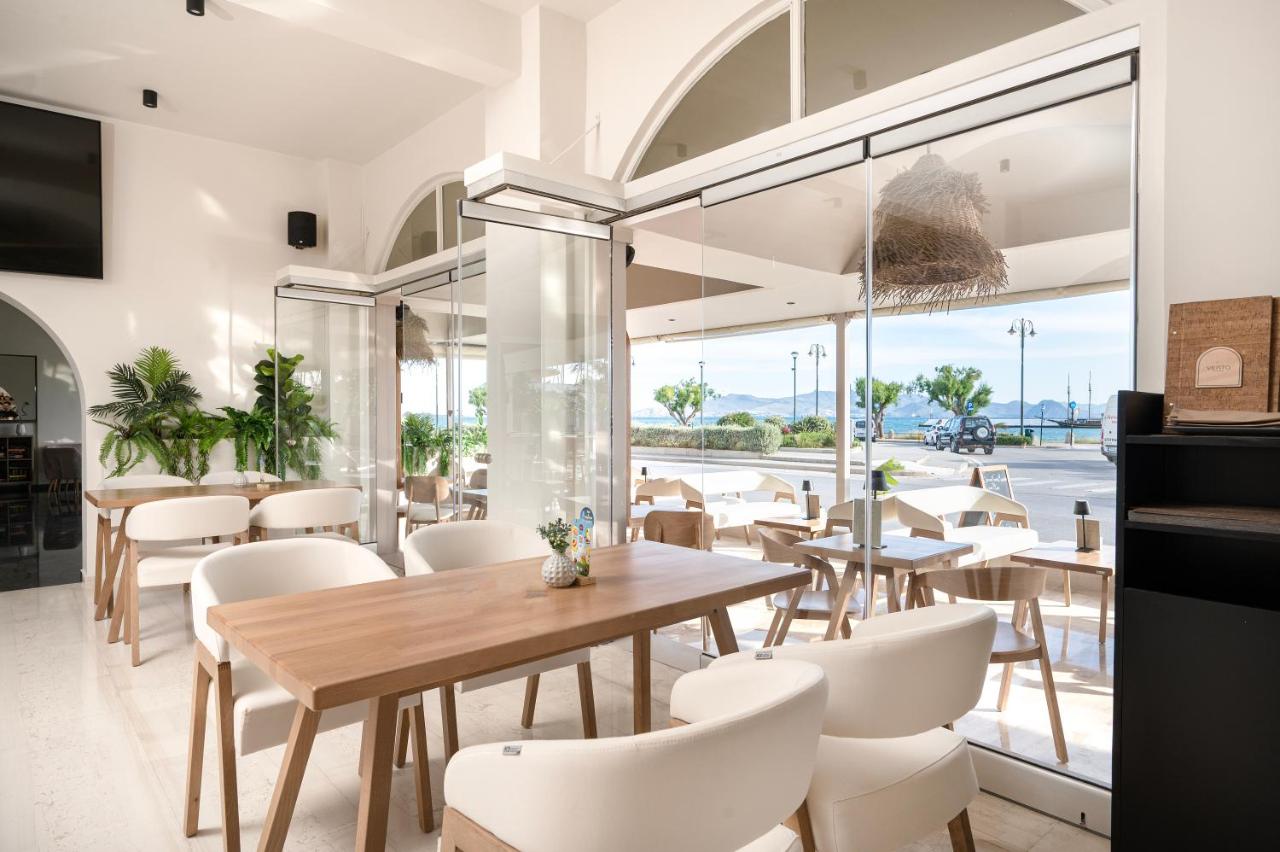 een restaurant met witte stoelen en tafels en een groot raam bij Zephyros Hotel in Kos-stad