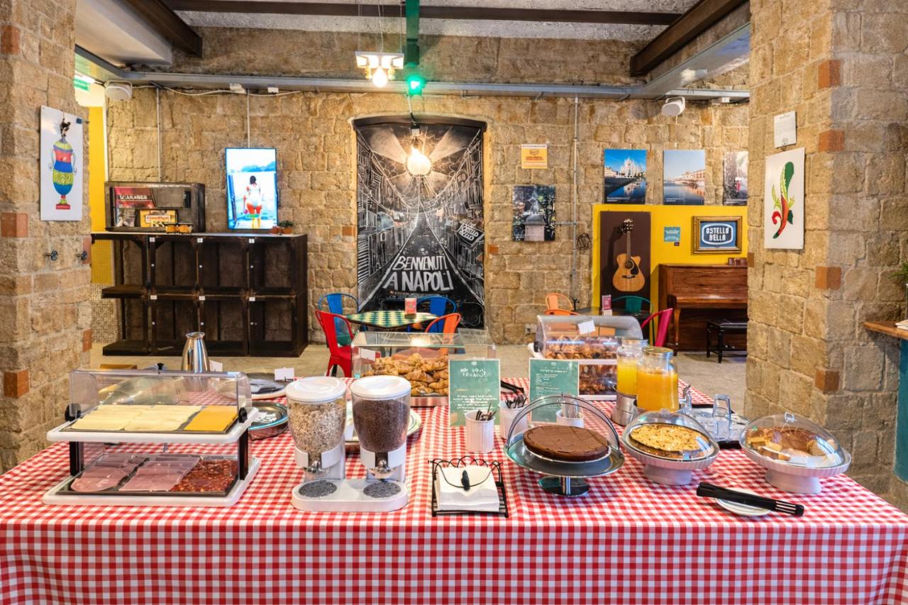 een tafel met eten op een rood-wit geblokt tafelkleed bij Ostello Bello Napoli in Napels