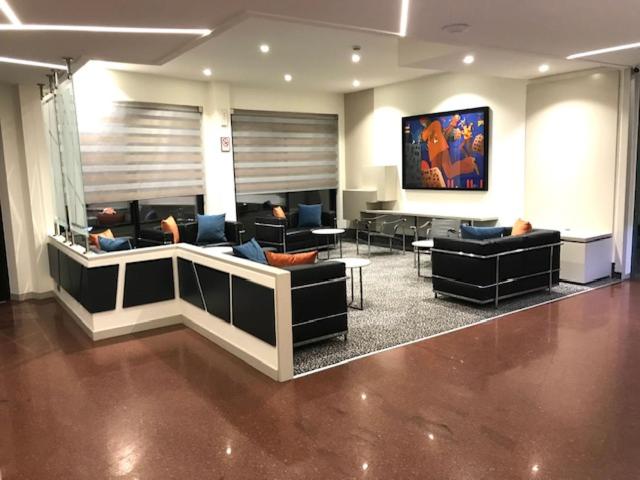 een lobby met banken en tafels in een kamer bij Cardano Hotel Malpensa in Cardano al Campo