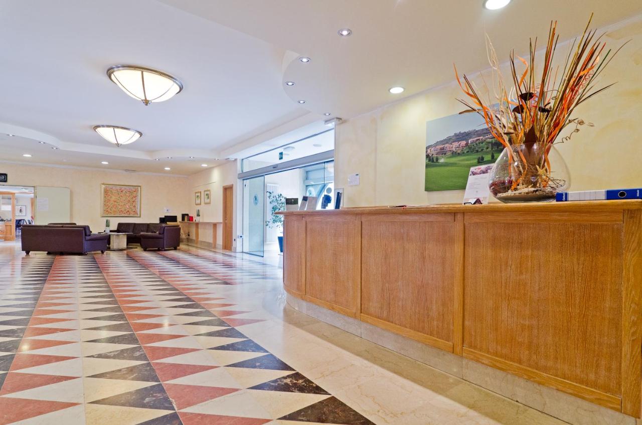 een lobby met een receptiebalie en een wachtkamer bij Castellaro Golf Resort in Castellaro