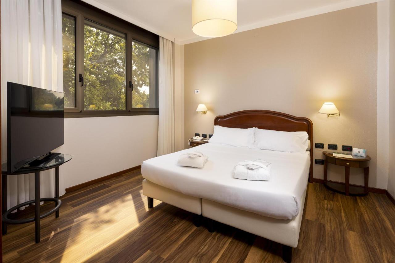 een slaapkamer met een bed waarop twee handdoeken liggen bij Best Western Air Hotel Linate in Segrate