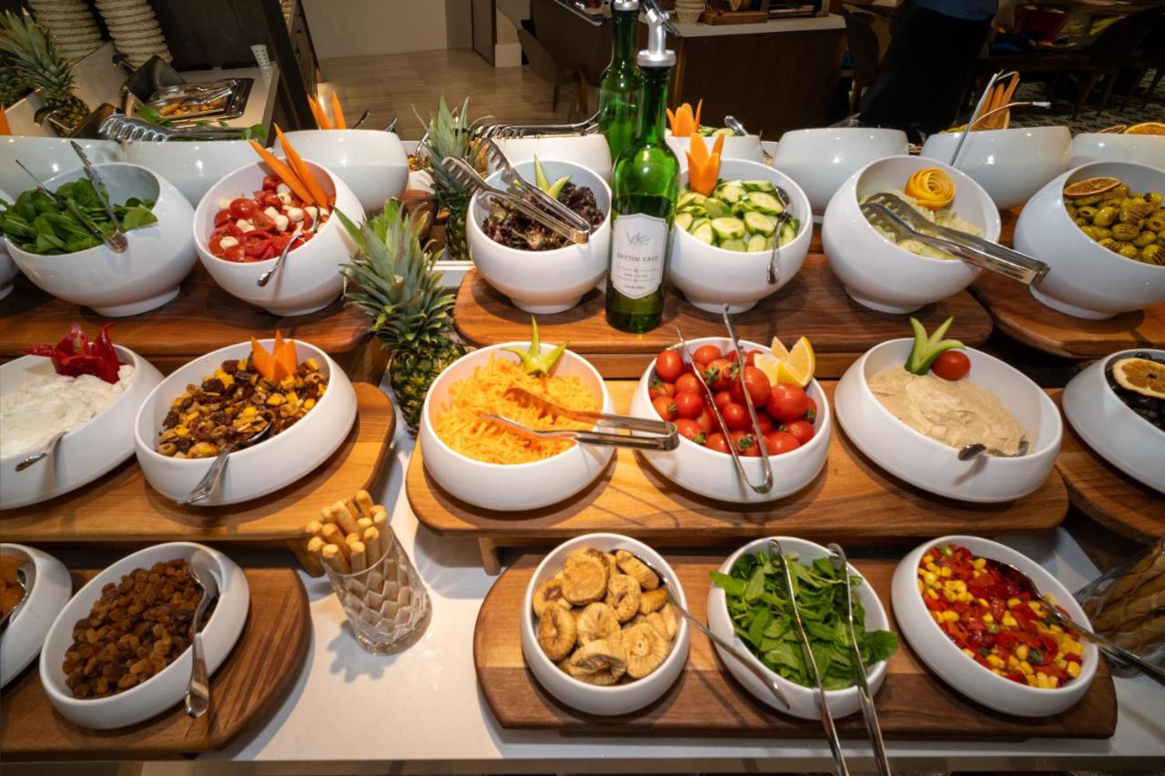 een buffet met kommen eten en flessen champagne bij Rayelin Hotel Old Town in Istanbul