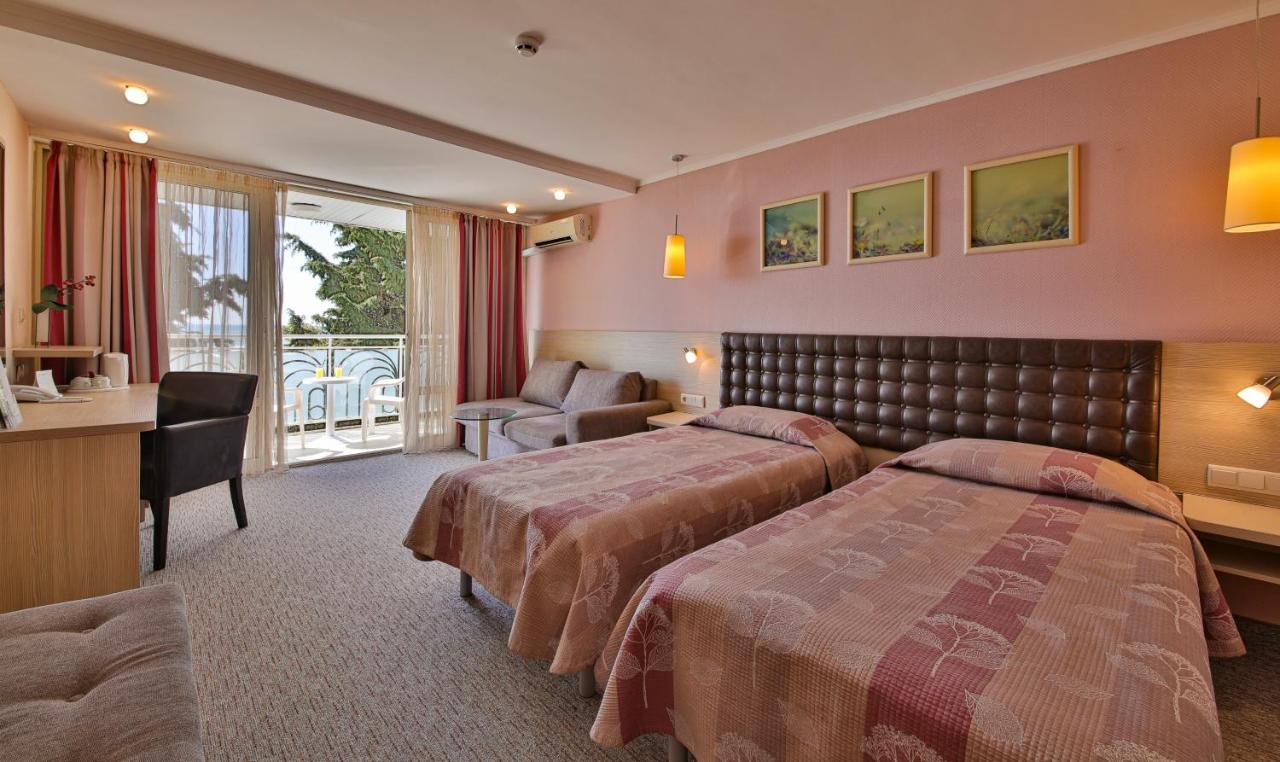 een hotelkamer met twee bedden en een bureau bij Hotel Sandy Beach in Albena