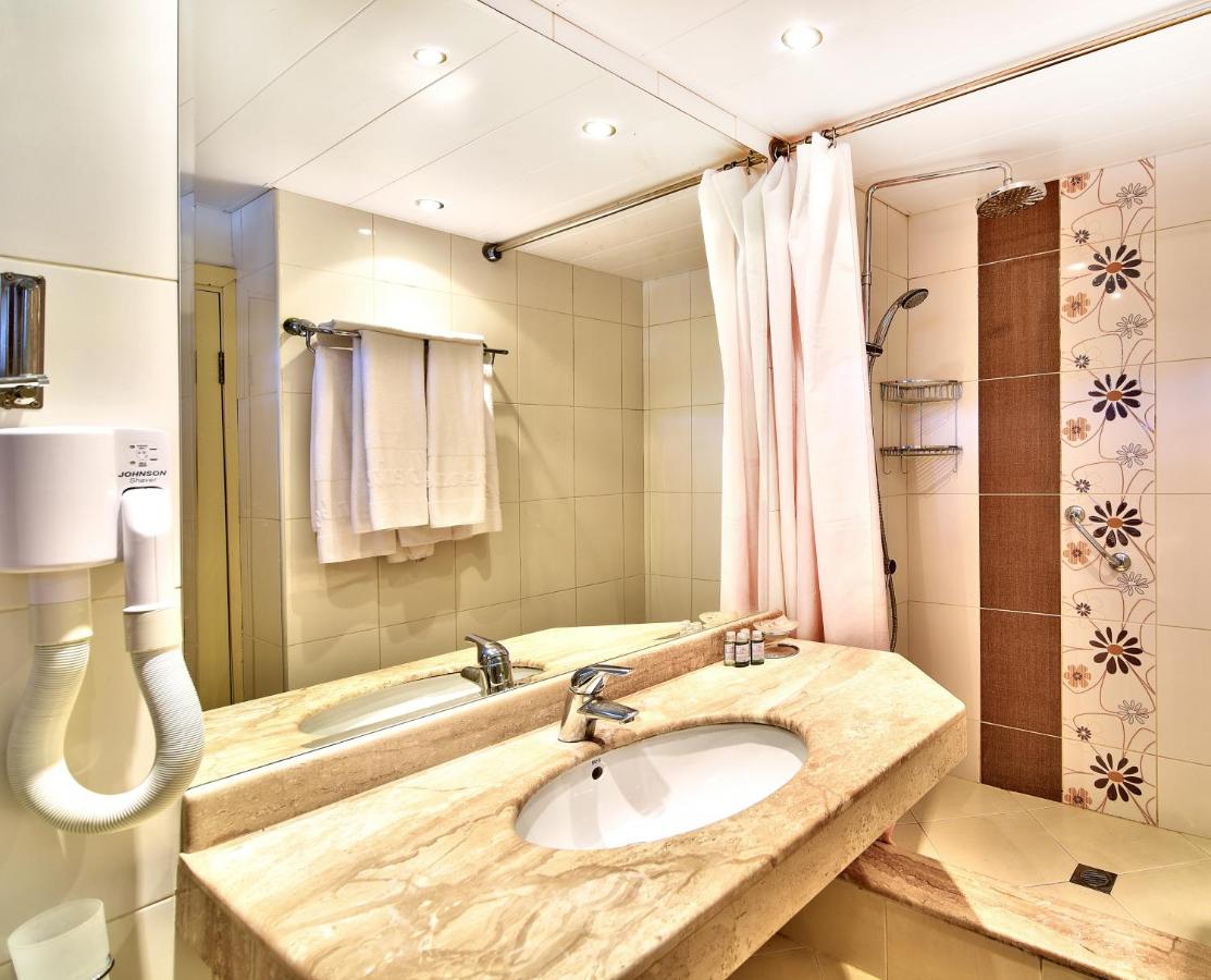 een badkamer met een wastafel en een grote spiegel bij Hotel Sandy Beach in Albena