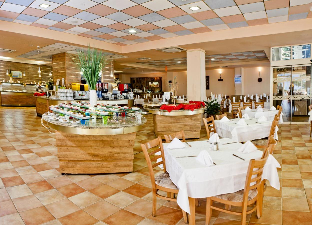 een eetkamer met witte tafels en stoelen bij Hotel Sandy Beach in Albena