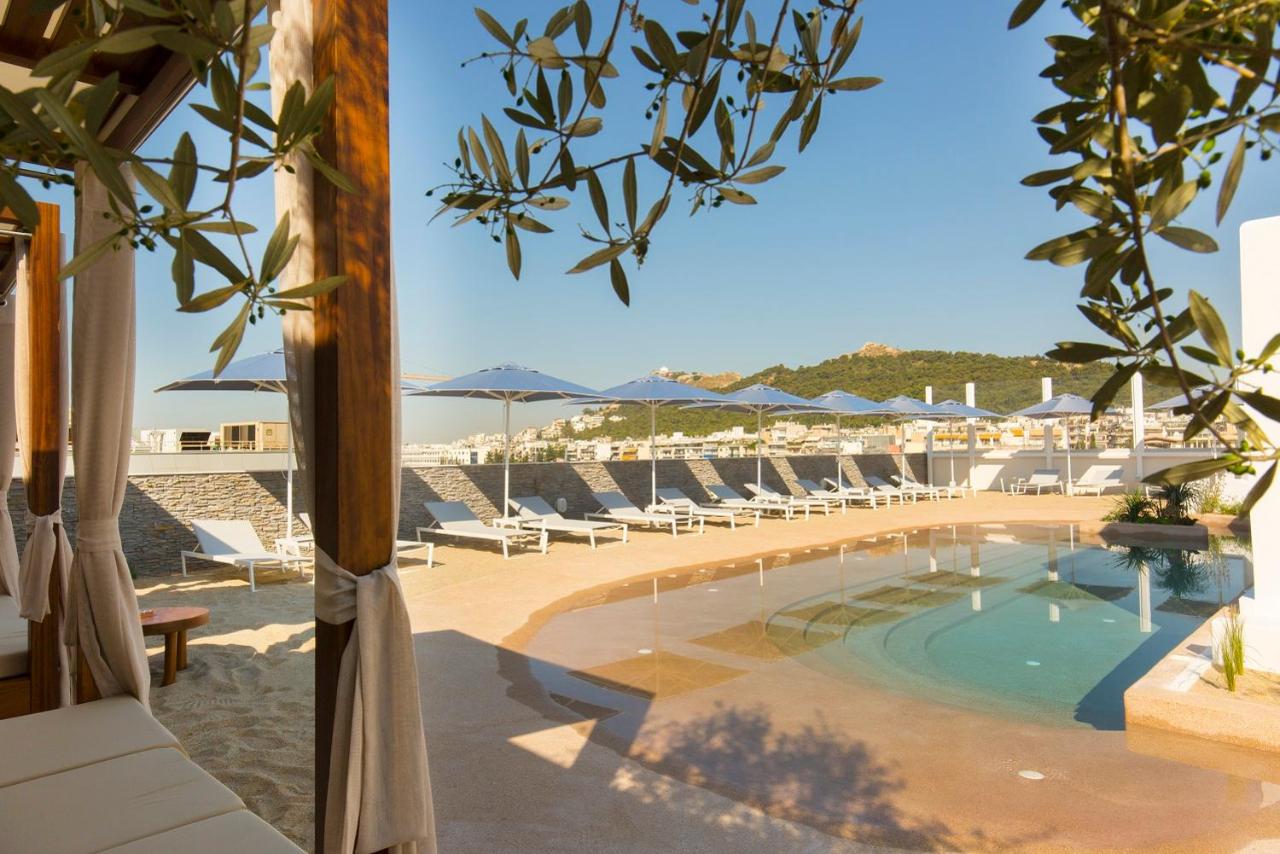 een zwembad met ligstoelen en parasols bij Airotel Alexandros in Athene