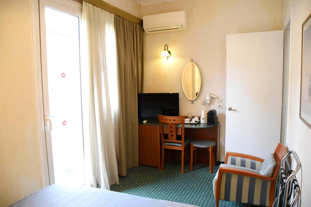 een hotelkamer met een bed en een bureau met een spiegel bij Adrian Hotel in Athene