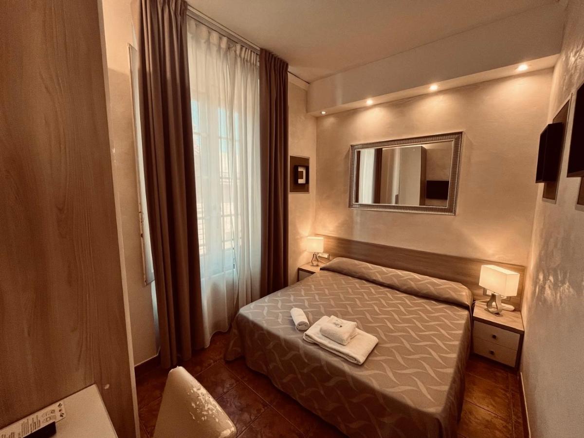 een kleine slaapkamer met een bed en een spiegel bij Hotel Alinari in Florence