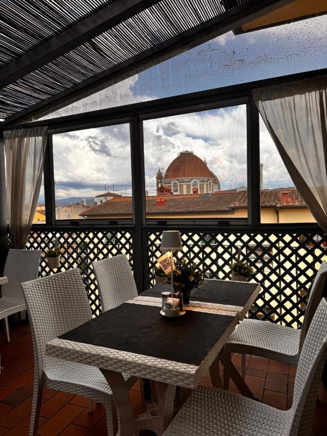 een tafel en stoelen op een balkon met uitzicht bij Hotel Alinari in Florence