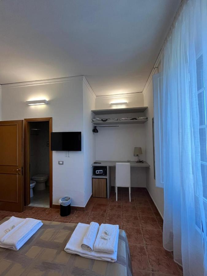 een kamer met twee bedden, een bureau en een televisie bij Hotel Alinari in Florence