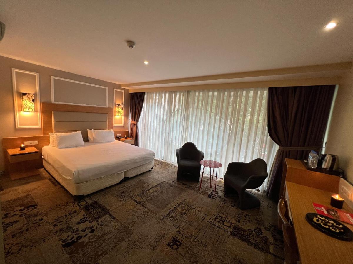 een hotelkamer met een bed en twee stoelen bij All Seasons Hotel in Istanbul