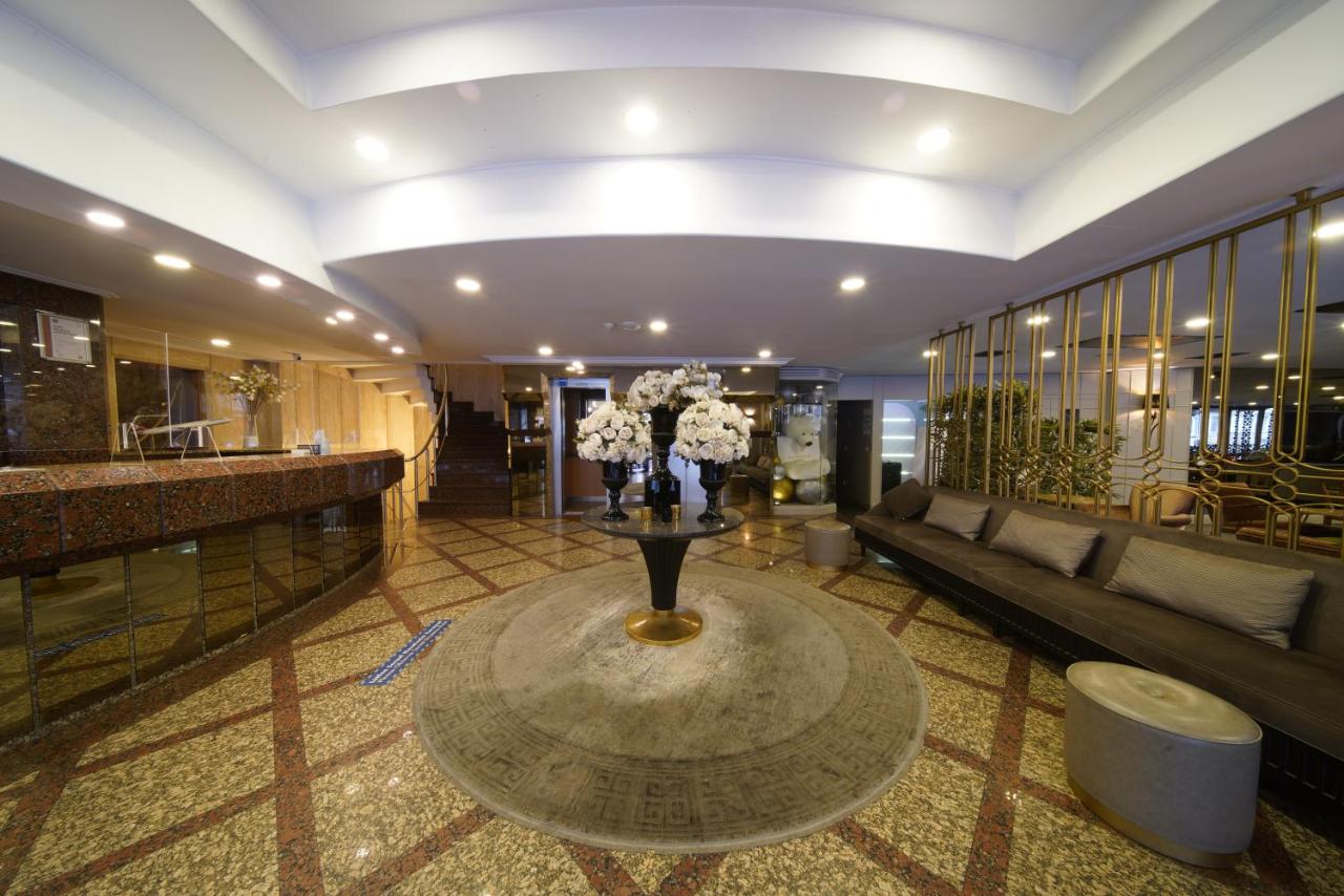 een lobby met een bank en een tafel met bloemen bij All Seasons Hotel in Istanbul