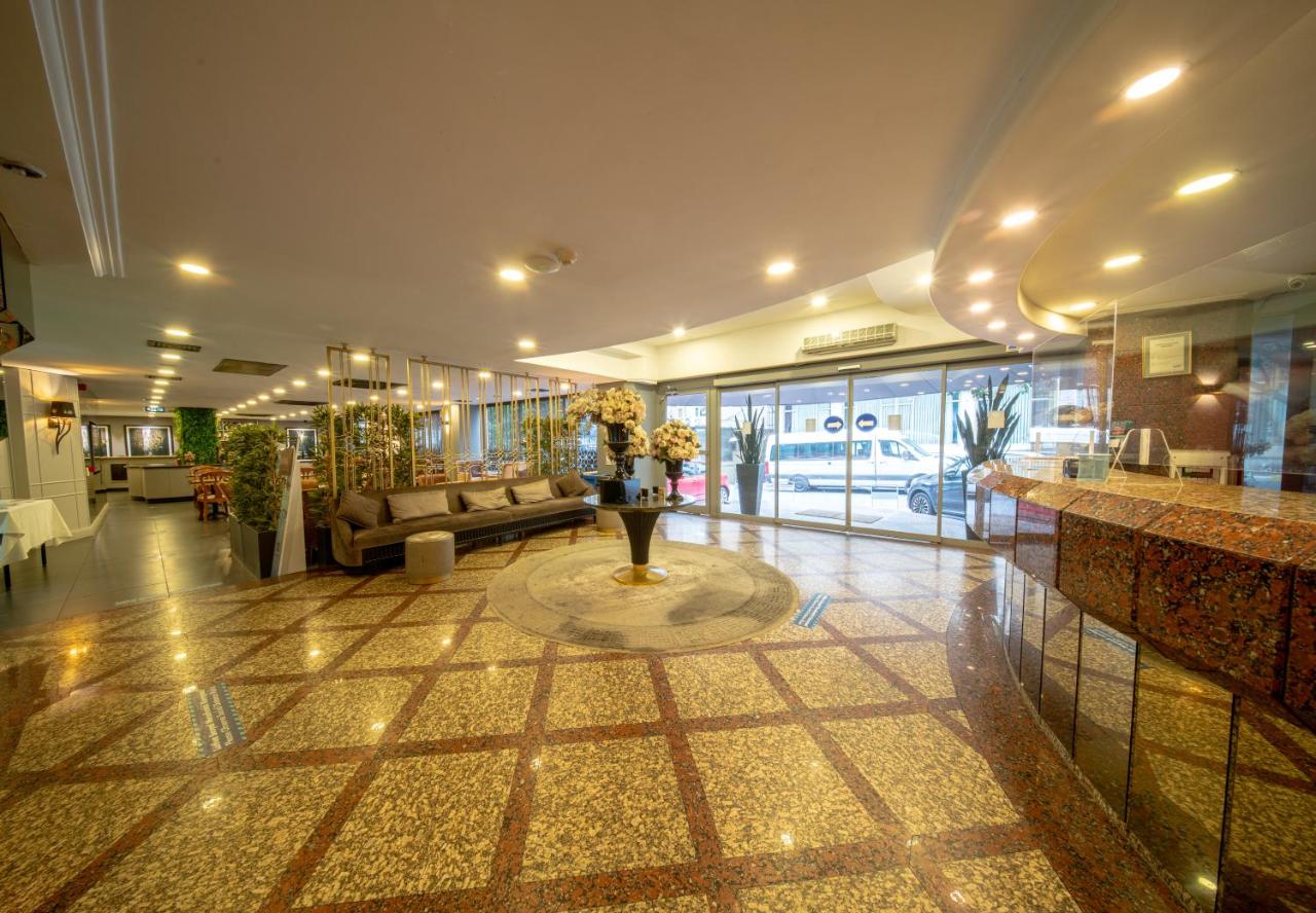 een lobby met een bank en bloemen in een gebouw bij All Seasons Hotel in Istanbul