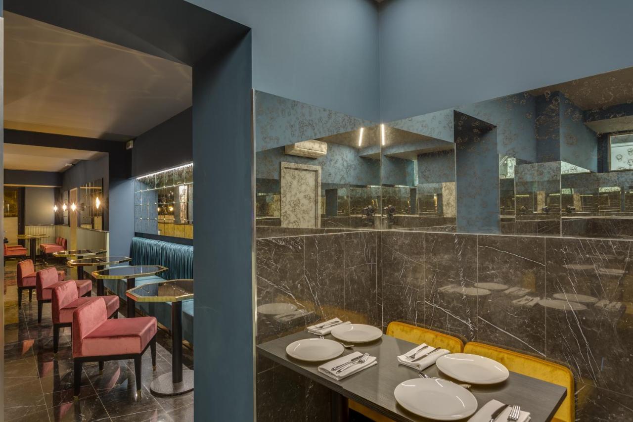 een restaurant met tafels en stoelen en een bar bij Otivm Hotel in Rome
